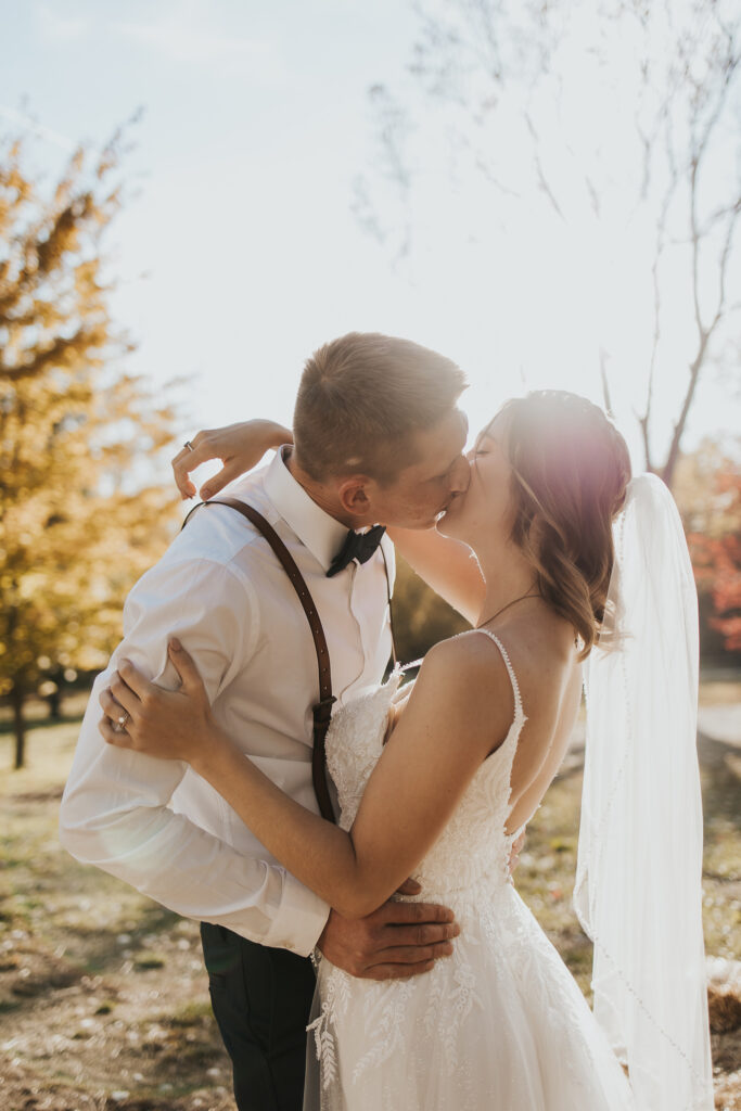 couple kiss during sunset in the pasture