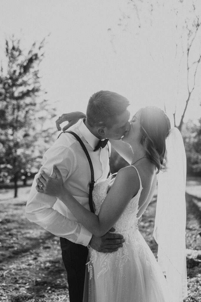 couple kiss during sunset in the pasture