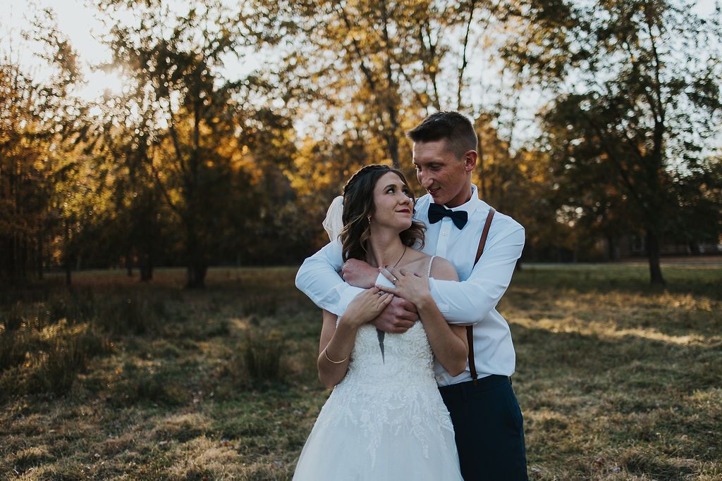 couple embrace in the pasture