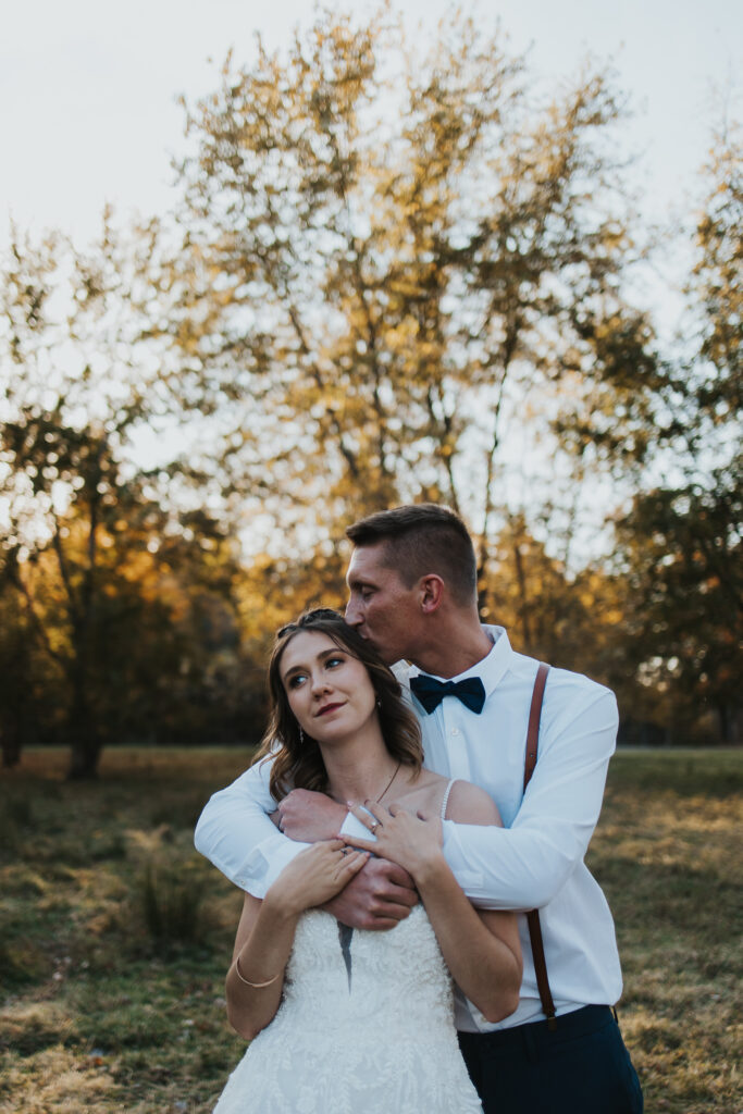 groom kisses bride's head