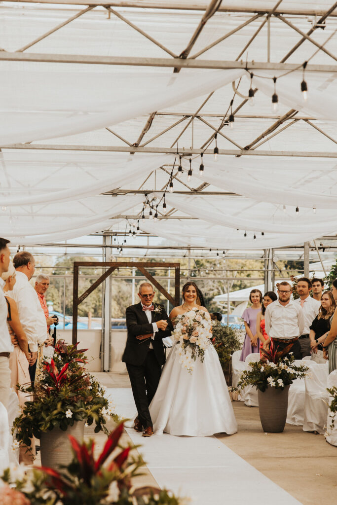 bride walks down aisle during wedding ceremony