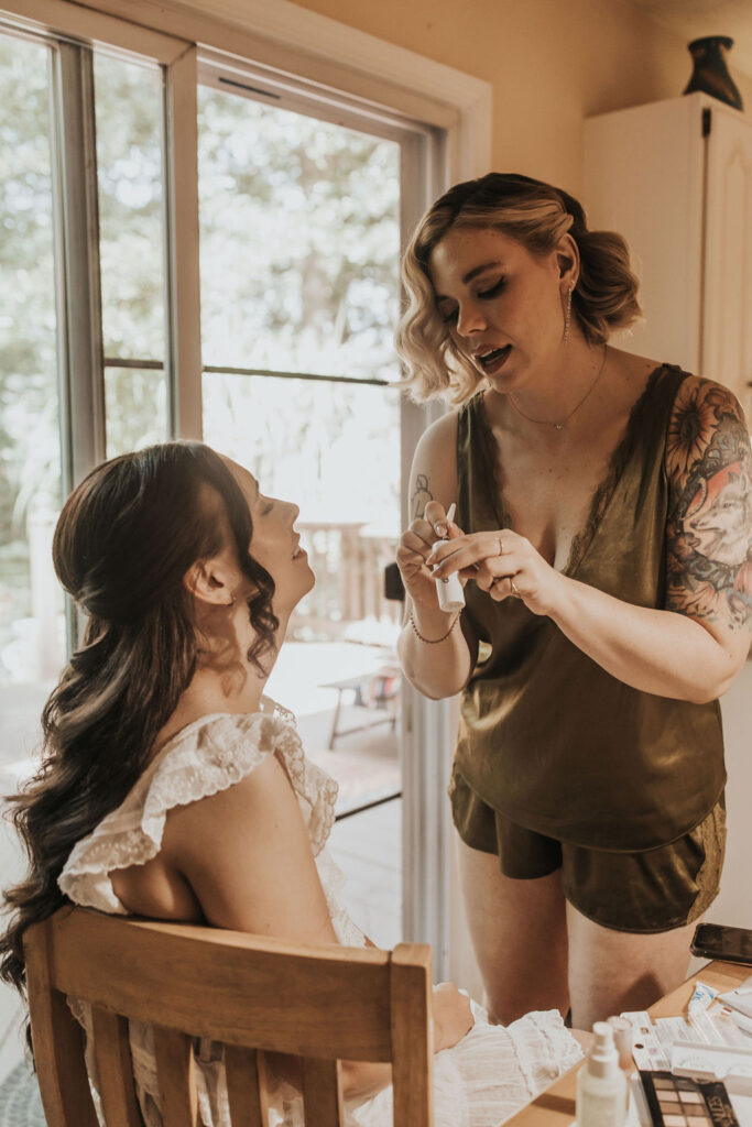 bride has makeup put on during wedding getting ready