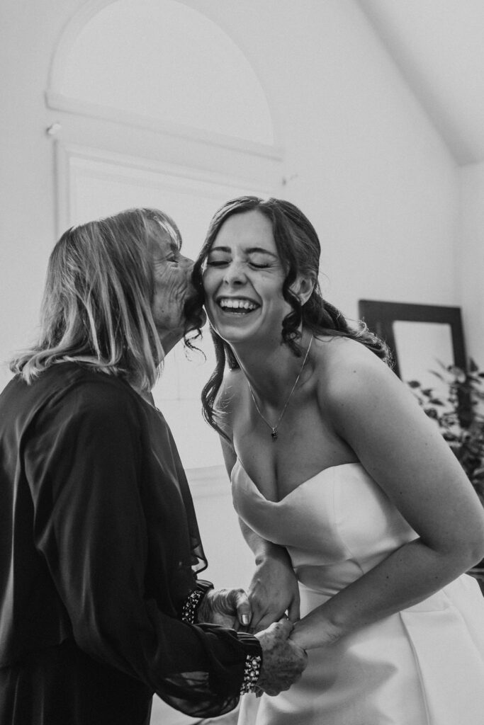 grandmother kisses bride on the cheek