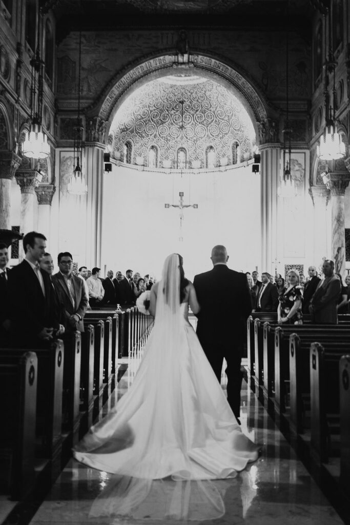 bride walks down aisle during church wedding ceremony