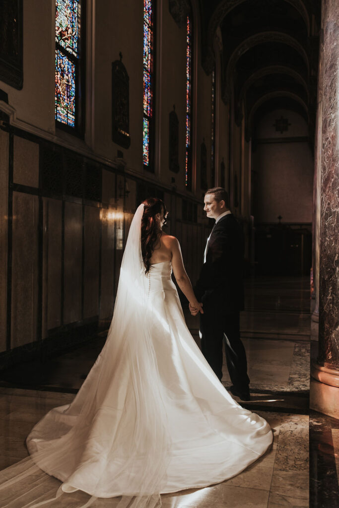 couple holds hands in church after wedding 