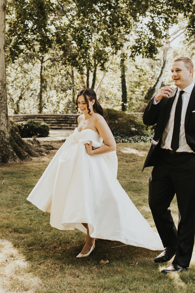 couple walks in garden as one of their Cleveland wedding locations