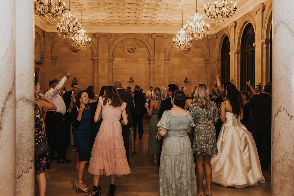 couple dances with guests at wedding reception