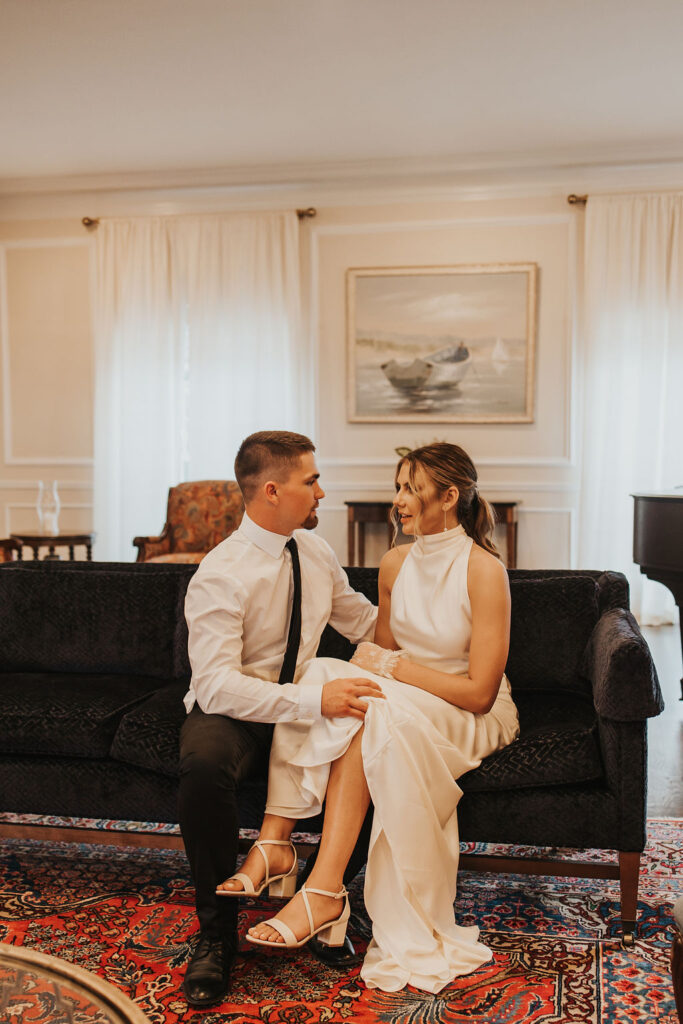 couple sits on couch together during wedding first look