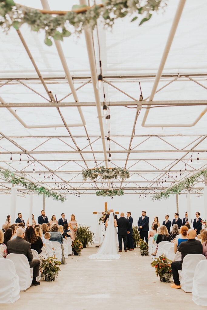 couple exchanges vows during wedding ceremony at greenhouse Central Ohio wedding venues