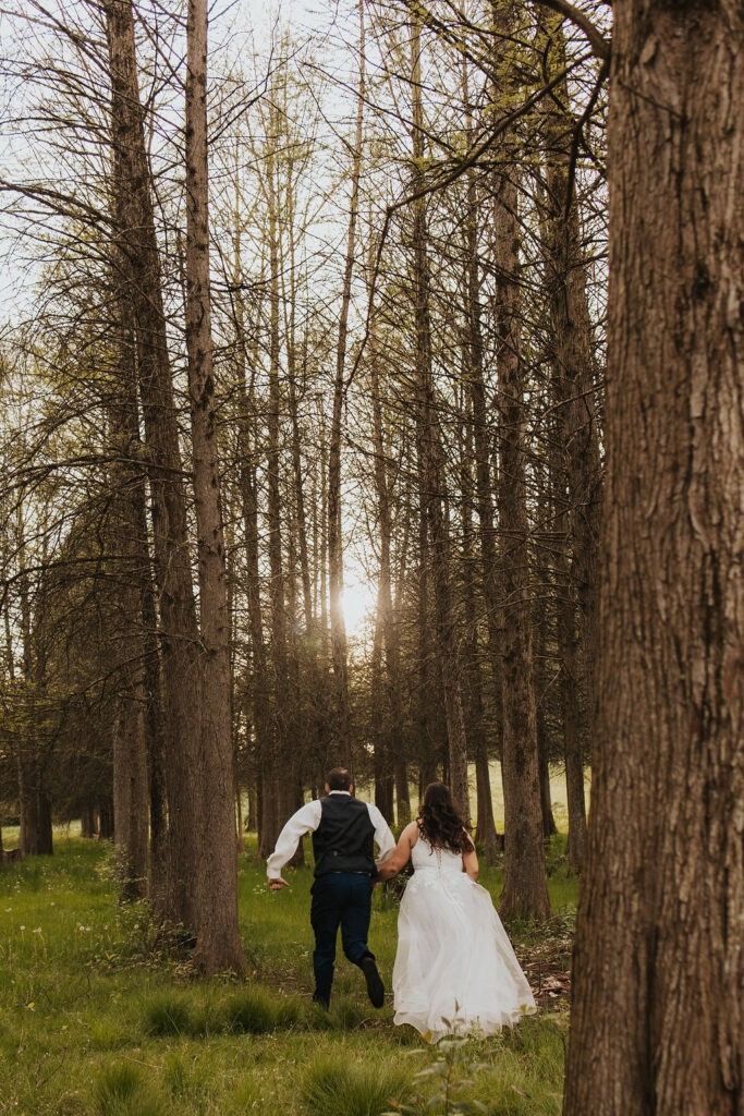 couple runs through woods at Central Ohio wedding venues