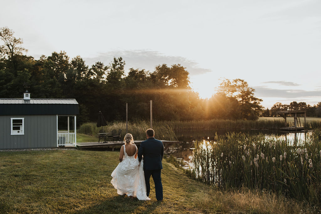 couple walks along outdoor wedding ceremony location 