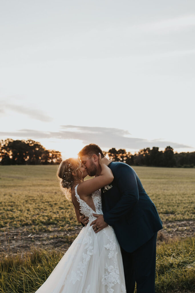 couple kisses in field at Harvest Moon of the Central Ohio wedding venues