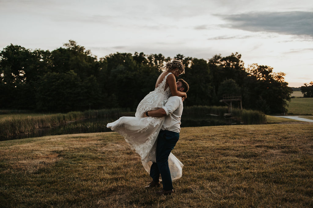 couple embraces in field at Central Ohio wedding venues