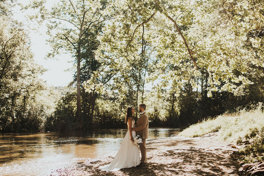 couple embraces beside river