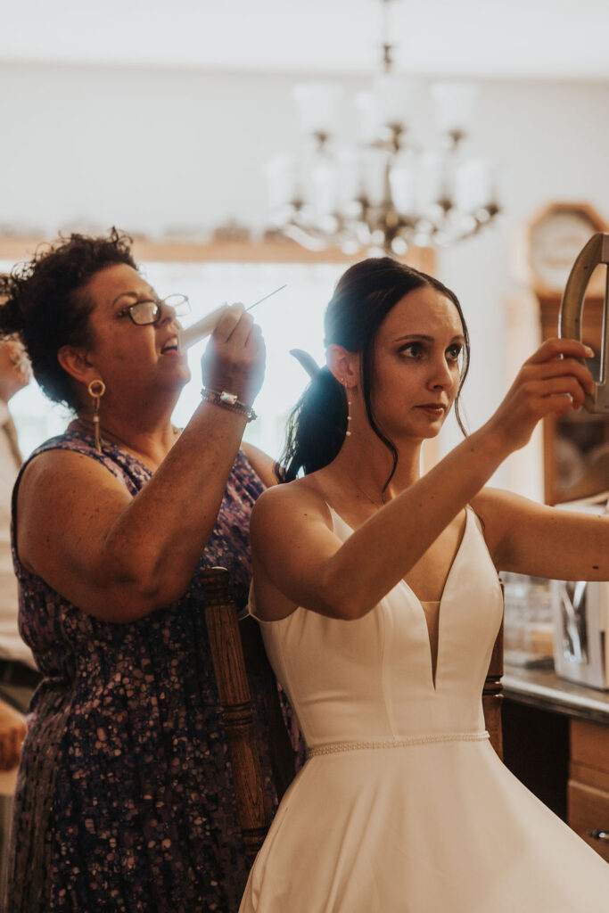 bride has hair done on wedding day