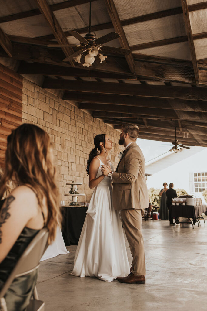 couple dances together at backyard wedding reception 