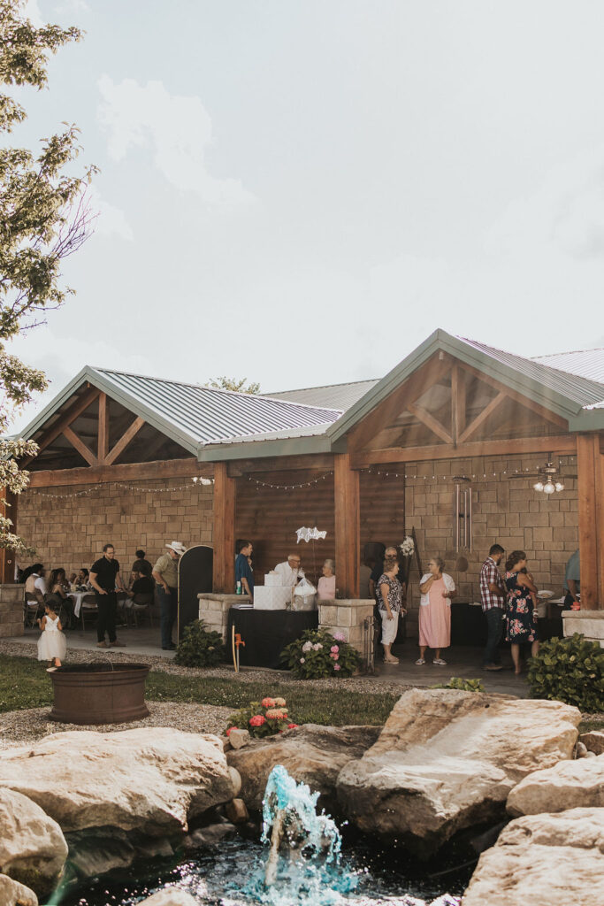 guests walk around at backyard wedding reception 