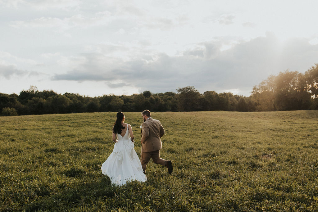 couple runs in field at sunset