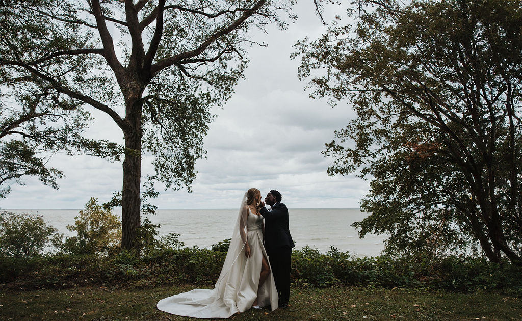 couple kisses during wedding first look beside Lake Eerie 