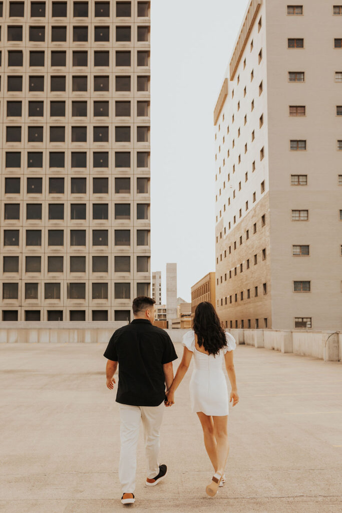 couple walk together holding hands on rooftop parking garage in downtown columbus ohio