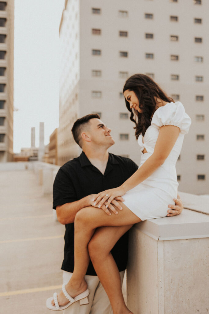 couple pose on ledge of parking garage