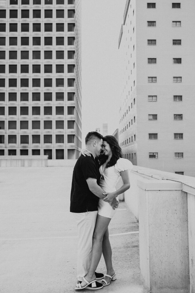 couple pose by ledge of parking garage