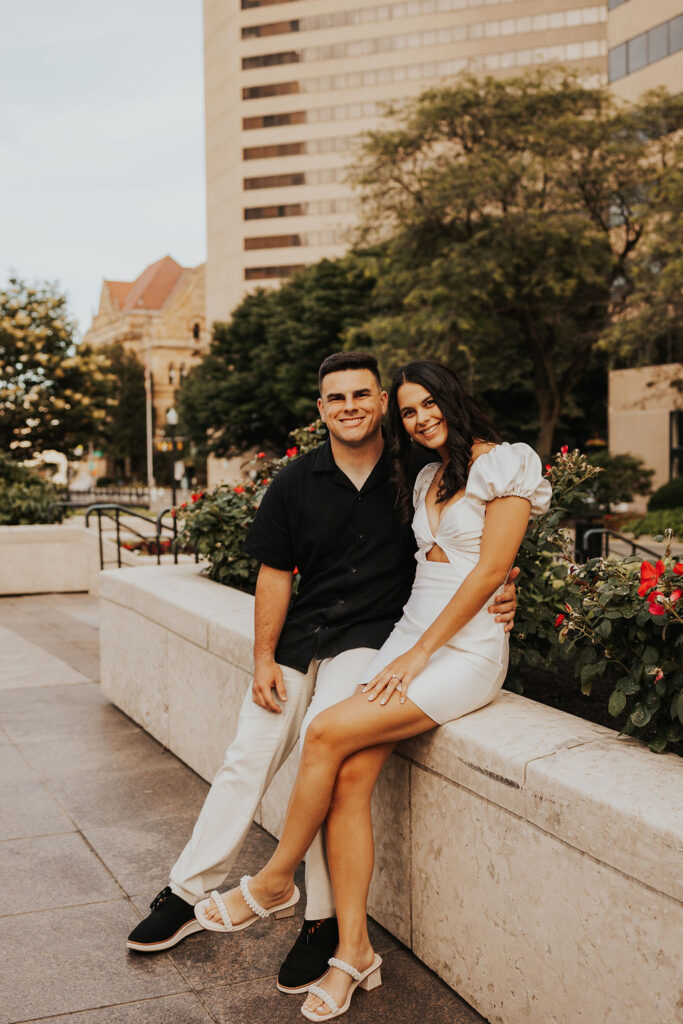 couple sit on ledge along street of downtown columbus ohio