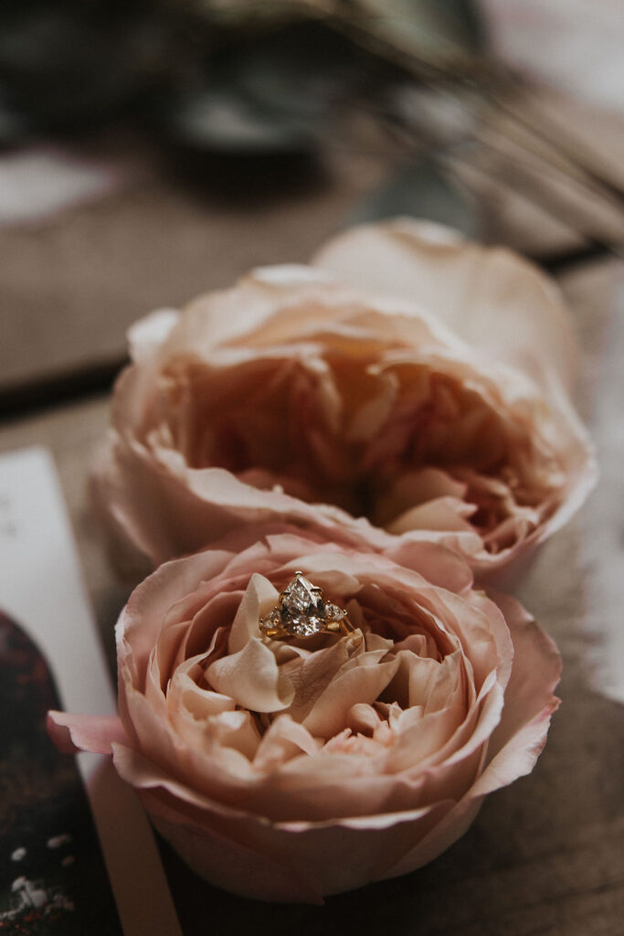 engagement ring lay in pink flowers