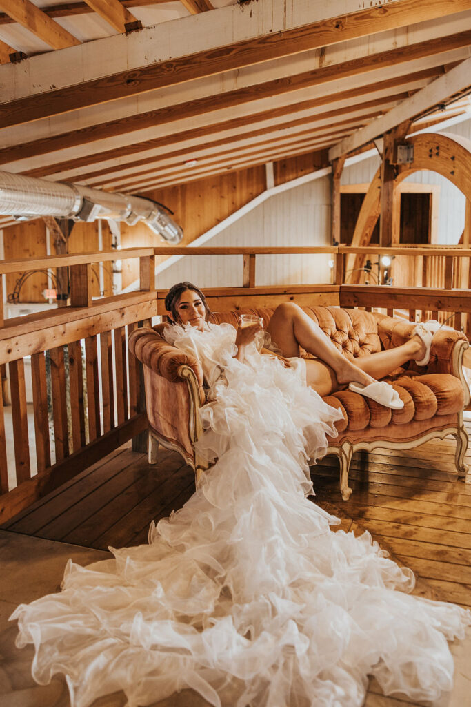 bride poses on couch while getting ready