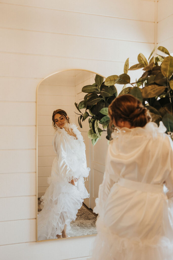 bride looking at herself in the mirror while getting ready