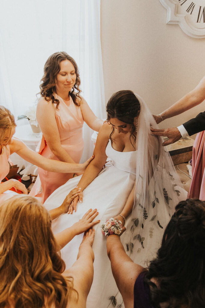 bridesmaids pray with bride before ceremony