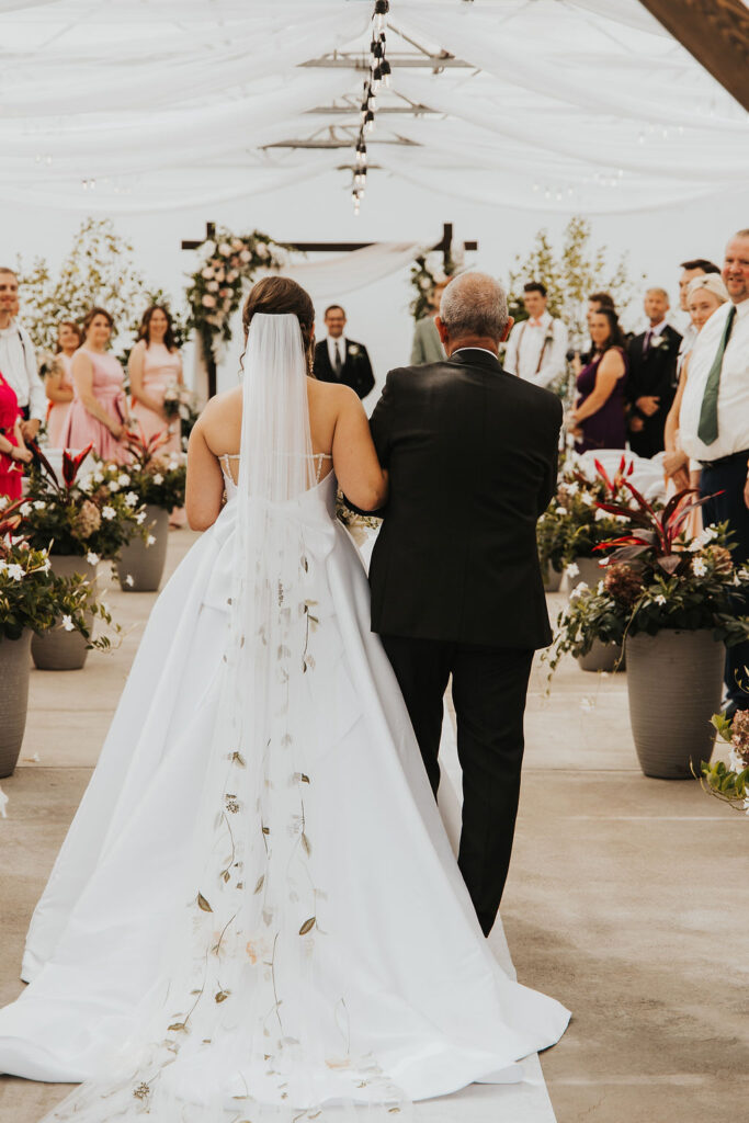 bride and father walk down the aisle of Ohio greenhouse wedding