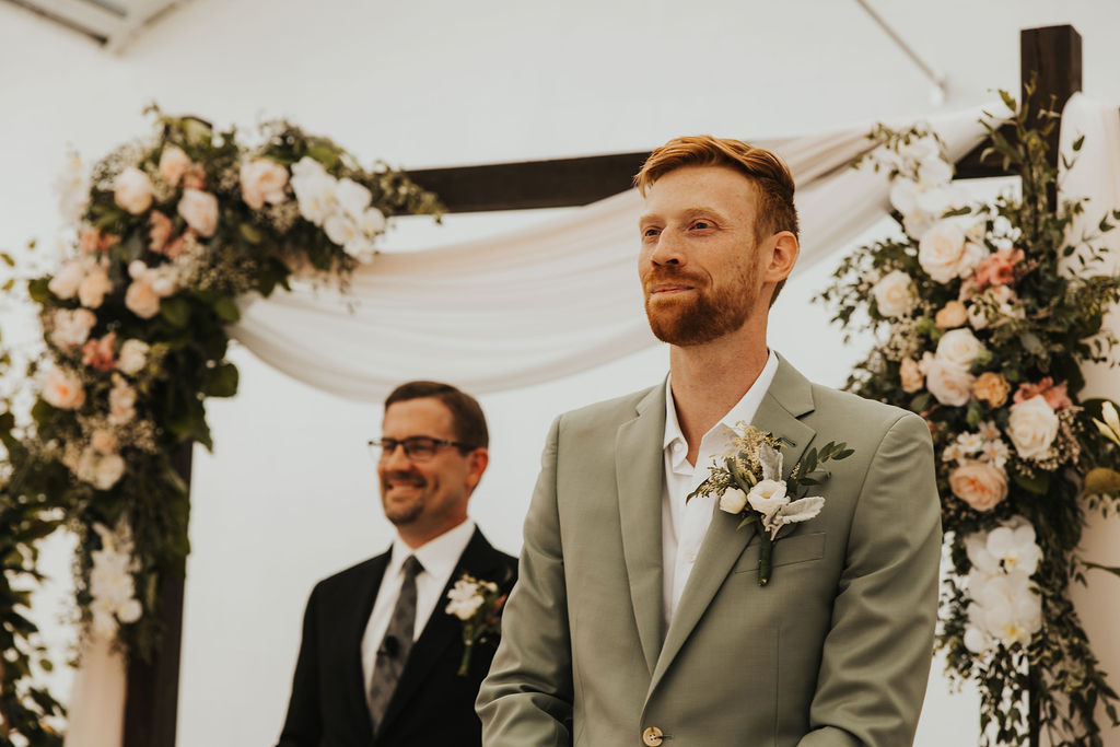 groom smiles during ceremony at Ohio greenhouse wedding