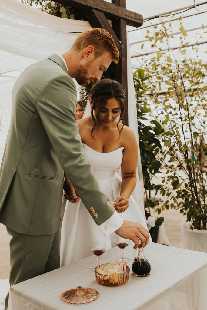 couple take communion together during ceremony