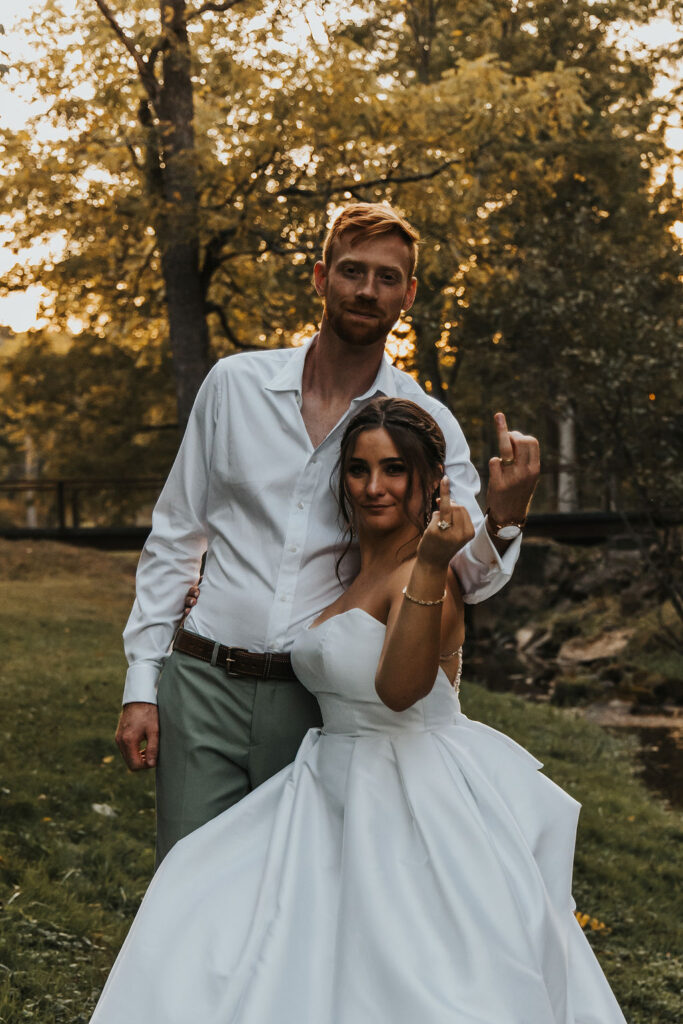 couple pose together at sunset showing off their wedding rings
