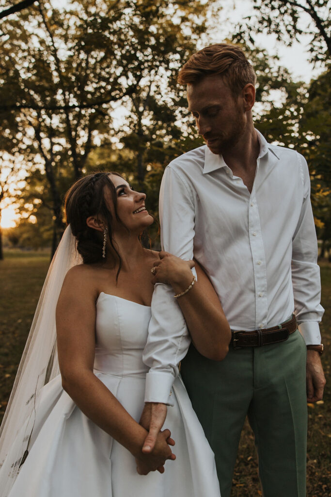 couple pose together holding hands at sunset