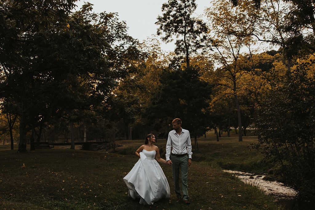 couple walking along river holding hands