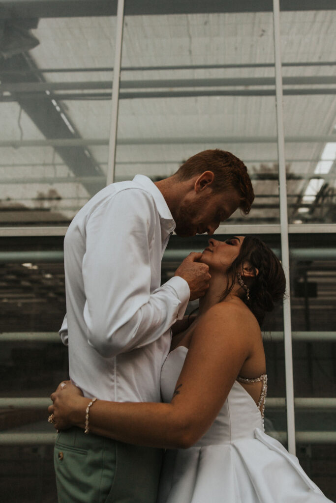 couple kiss in front of an Ohio greenhouse