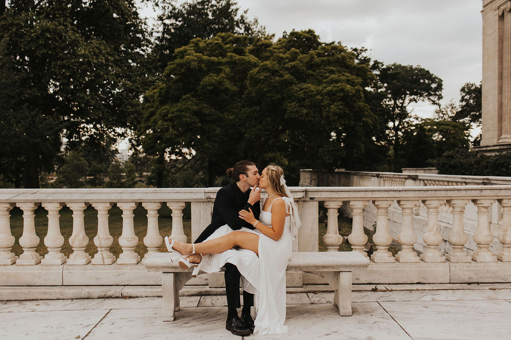 couple kiss on marble benches at the Cleveland Museum of Art