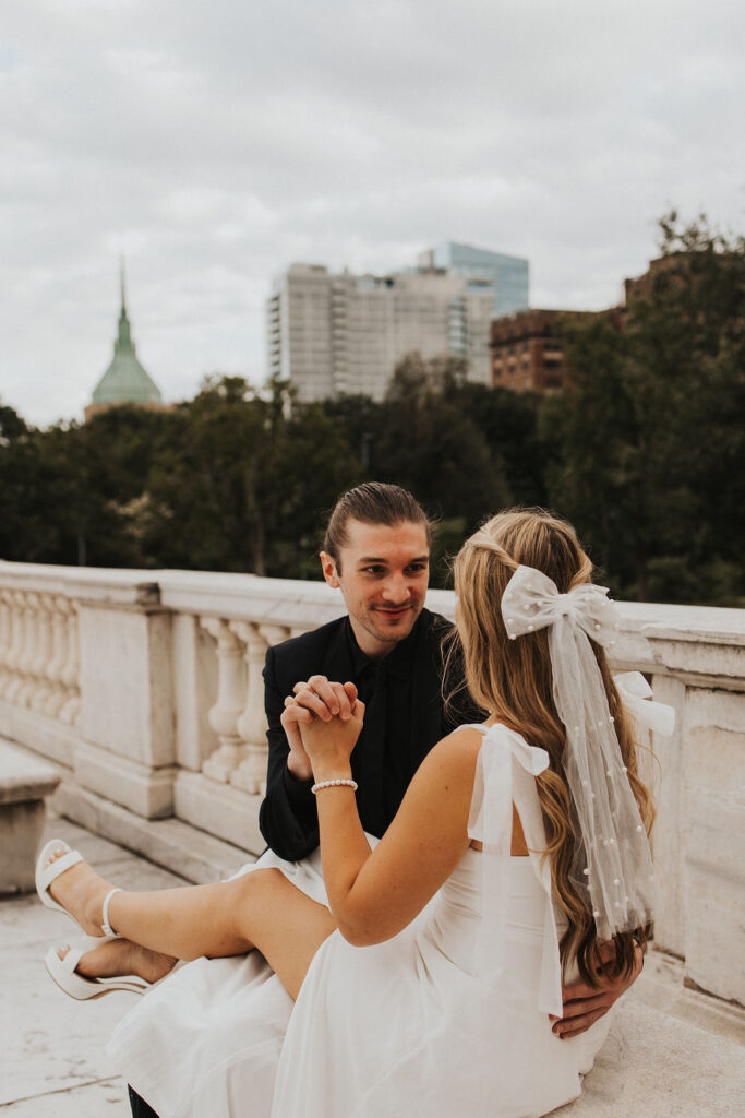 couple sitting on marble bench holding hands