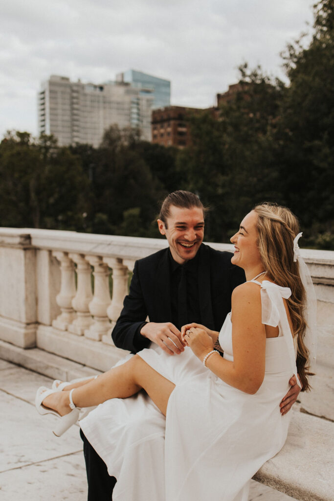 couple laughing together sitting on marble bench