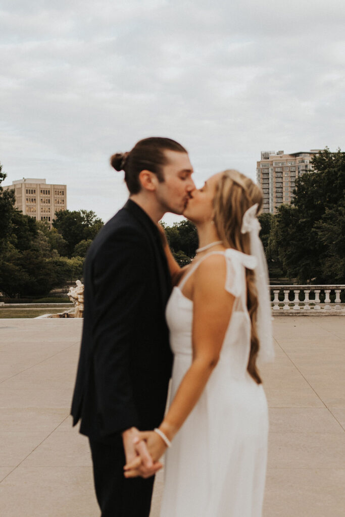 couple kiss with the city in the background