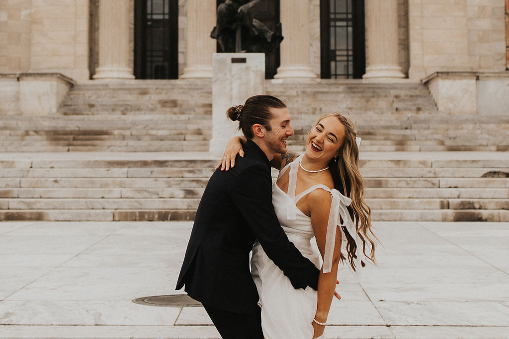 couple embrace while laughing during engagement photos