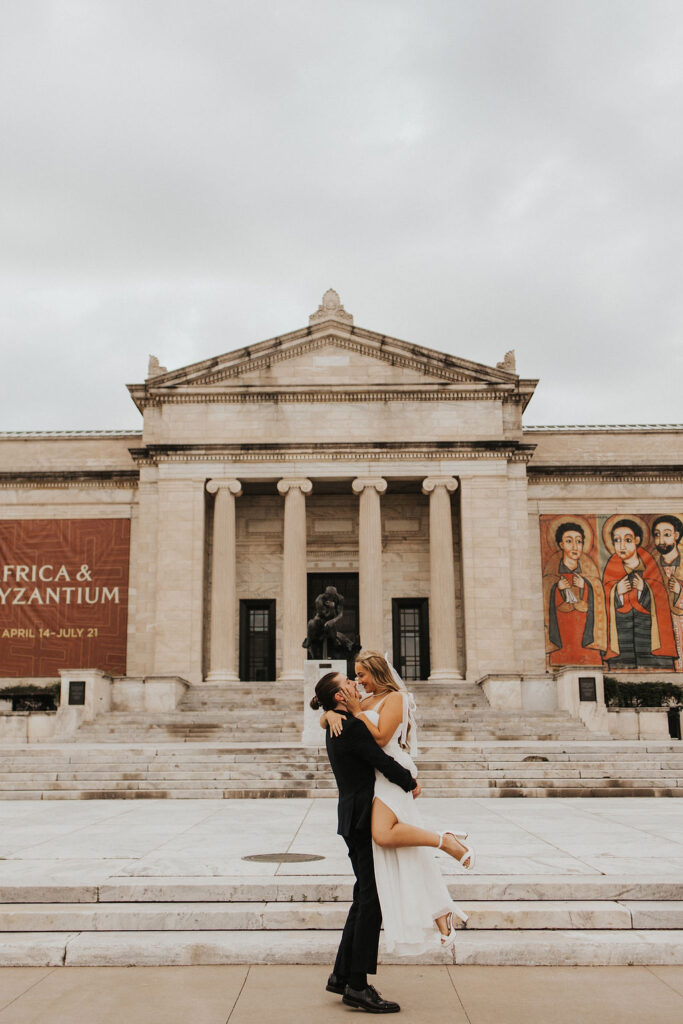 couple embrace in front of the Cleveland Museum of Art