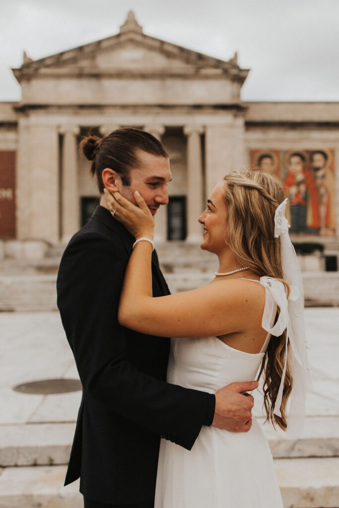 couple embrace in front of the Cleveland Museum of Arts