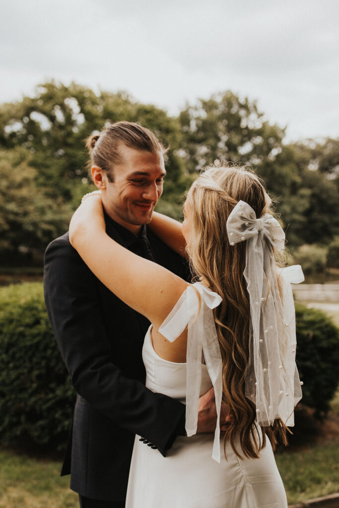couple embrace with greenery in background