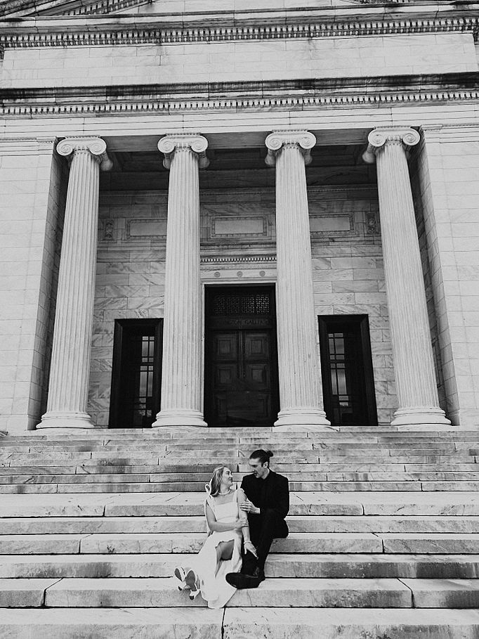 couple sitting on steps in front of pillars