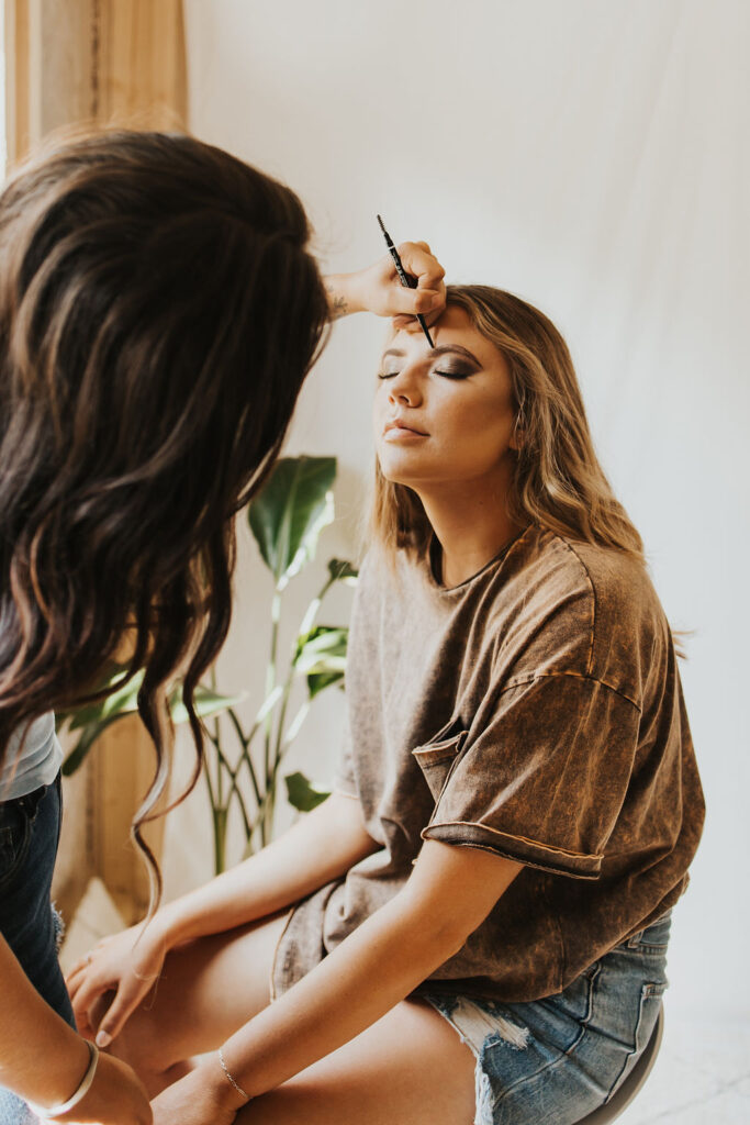 bride getting makeup done in bridal suite