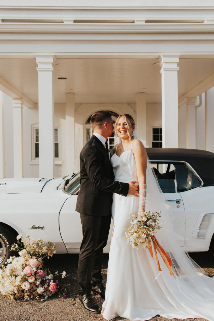 couple poses with car in front of Westbrook Country Club