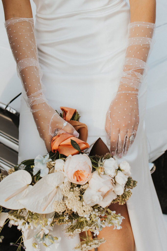 detail shot of bride's gloves and wedding flowers